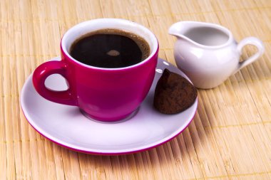 Espresso kahve parlak pembe seramik Kupası ve bitter çikolata bir fincan tabağı üzerinde gelen şeker bölümü sürahi için krem yakınındaki olmak