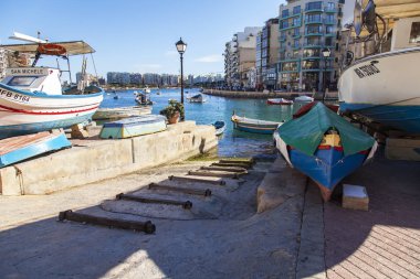 San Giljan, Malta, 7 Ocak 2019 tarihinde. Spinola Körfezi'nin güzel dolgu. Yürüyüş ve balıkçı tekneleri defne Spinola kıyısında güneşli kış günü