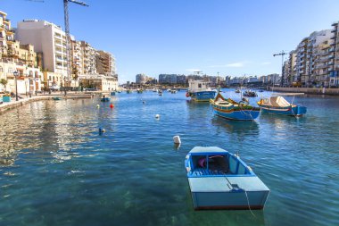 San Giljan, Malta, 7 Ocak 2019 tarihinde. Yürüyüş ve balıkçı tekneleri pitoresk defne Spinola içinde güneşin ile kış sabahları yanıyor. Uzaktan güzel dolgu