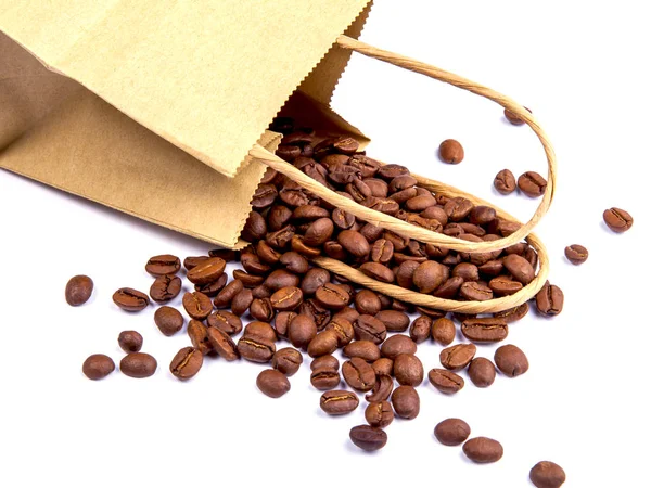 Semena Kávy Jsou Roztroušeny Blízkosti Papírovém Balení Bílém Stole — Stock fotografie