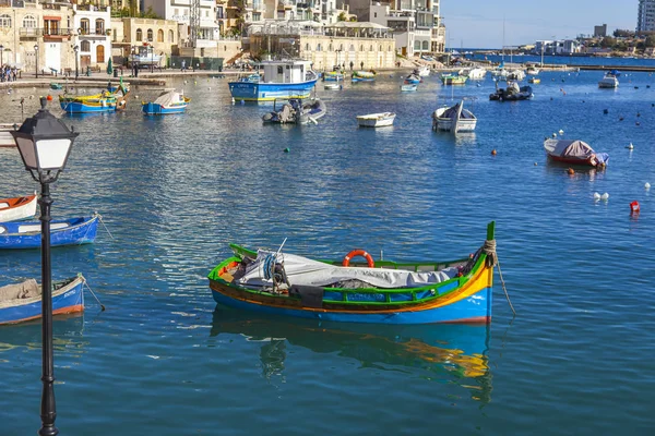 San Giljan, Malta, 7 Ocak 2019 tarihinde. Yürüyüş ve balıkçı tekneleri pitoresk defne Spinola içinde güneşin ile kış sabahları yanıyor. Uzaktan güzel dolgu