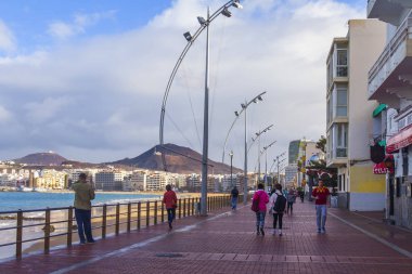 Las Palmas de Gran Canaria, İspanya, 10 Ocak 2018 üzerinde. Playa de Las Canteras plaja yakın dolgu yürüyüşte insanlar Kış Güneşi ile yaktı.
