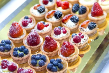 Kafede bir şov penceresinde küçük lezzetli kekler