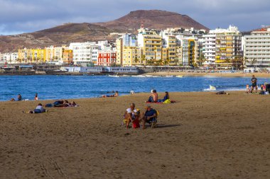 Las-Palmas de Gran Canaria, Ispanya, 8 Ocak 2018. Kış güneşi, Atlantik Okyanusu 'nun kıyısında, Playa de Las Canteras plajına yanar. İnsanlar su kenarına yakın bir dinlenme var