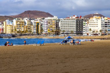 Las-Palmas de Gran Canaria, Ispanya, 8 Ocak 2018. Kış güneşi, Atlantik Okyanusu 'nun kıyısında, Playa de Las Canteras plajına yanar. İnsanlar su kenarına yakın bir dinlenme var