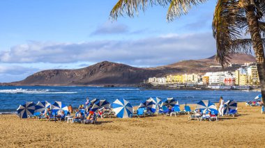 Las-Palmas de Gran Canaria, Ispanya, 8 Ocak 2018. Kış güneşi, Atlantik Okyanusu 'nun kıyısında, Playa de Las Canteras plajına yanar. İnsanlar su kenarına yakın bir dinlenme var
