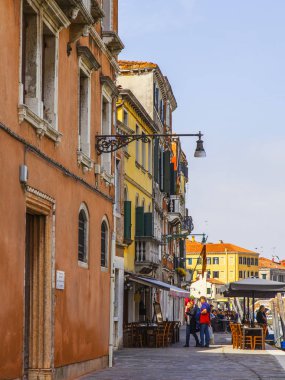 Venedik, İtalya, 25 Nisan 2019 tarihinde. İnsanlar tipik Venedik caddesi boyunca giderler.