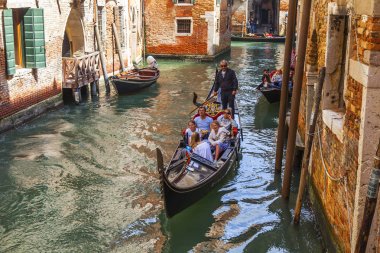 Venedik, İtalya, 25 Nisan 2019 tarihinde. Tipik antik binaların bir ortamda dar kanal üzerinde bir gondol üzerinde yürümek