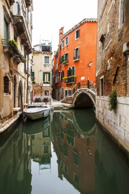 Venedik, İtalya, 25 Nisan 2019 tarihinde. Kanal üzerinden köprü ile pitoresk dar sokak. Kıyıdaki eski binaların tipik mimari kompleksi