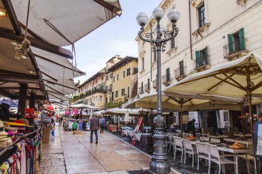 Verona, İtalya, 25 Nisan 2019 tarihinde. Piazza Erbe Meydanı'nda pitoresk sokak kafe tabloları