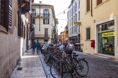 Verona, İtalya, 24 Nisan 2019 tarihinde. Eski şehirde dar pitoresk sokak. Bisikletler kaldırıma park edilmiş.