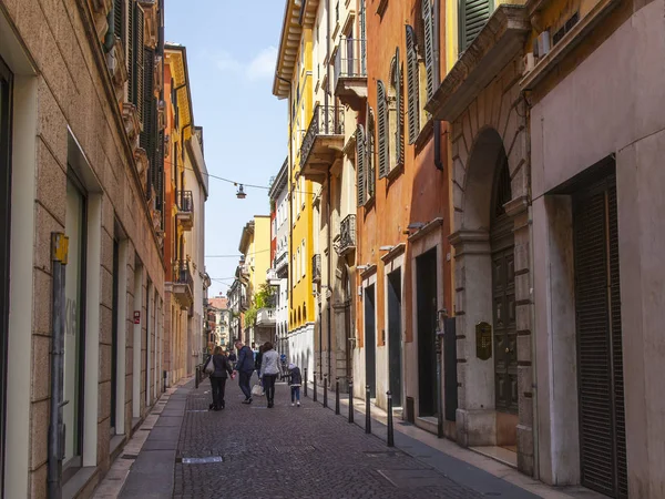 2019年4月24日 イタリアのヴェローナ 人々は旧市街の典型的な建築複合体と狭い絵のように美しい通りに沿って行きます — ストック写真