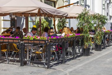 Moskova, Rusya, 16 Mayıs 2019. İnsanlar şehrin şehir merkezindeki caddelerinden biri olan Nikolskaya Caddesi'ndeki pitoresk kafede yemek yiyip dinleniyorlar.. 