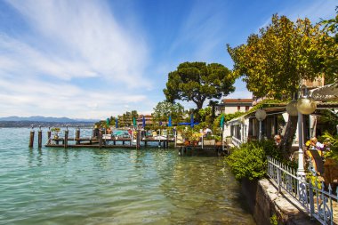 Sirmione, İtalya, 27 Nisan 2019 tarihinde. Garda Gölü'nün manzara manzarası. Tekneler için ahşap demirleme