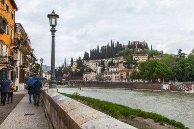 Verona, İtalya, 24 Nisan 2019 tarihinde. Bulutlu yağmurlu havalarda Adige Nehri ve dolgularının doğal panoramik manzarası