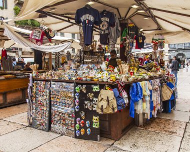 Verona, İtalya, 25 Nisan 2019 tarihinde. Piazza Erbe Meydanı'nda şehrin tarihi bir bölümünde Alışveriş Merkezleri. Bir gösteri penceresinde bölgeden çeşitli hediyelik eşyalar