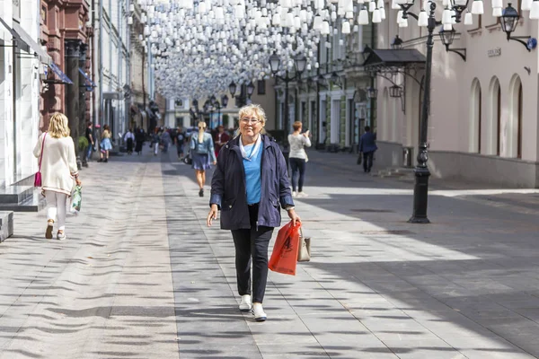 Moskova, Rusya, 27 Ağustos 2019. Kamerun Lane (Kamergerskyi) geleneksel bir mimari topluluk ile tipik Moskova sokaklarından biridir. Çekici yaşlı kadın yaya bölgesinde yürüyor