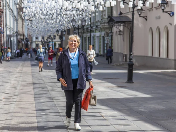 Moskova, Rusya, 27 Ağustos 2019. Kamerun Lane (Kamergerskyi) geleneksel bir mimari topluluk ile tipik Moskova sokaklarından biridir. Çekici yaşlı kadın yaya bölgesinde yürüyor
