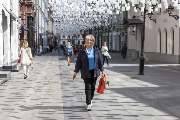 Moskova, Rusya, 27 Ağustos 2019. Kamerun Lane (Kamergerskyi) geleneksel bir mimari topluluk ile tipik Moskova sokaklarından biridir. Çekici yaşlı kadın yaya bölgesinde yürüyor