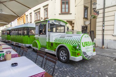 Ljubljana, Slovenya, 5 Ağustos 2019. Pitoresk şehir manzarası. Şehrin tarihi bölümünde güzel sokak, turistik elektrikli tren sokak kafe ile gider