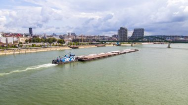 Belgrad, Sırbistan, 3 Ağustos 2019. Sava Nehri kıyısında modern çok katlı binalar. Kargo gemisi nehiryelken