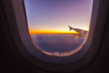 Şafakta güneşin altında uçan uçağın penceresinden bak.