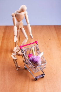 Alışveriş arabalarında taze sarımsak ve iki insan modeli.