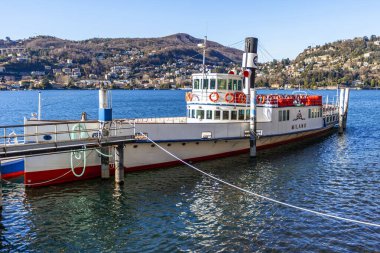 Como, İtalya, 12 Şubat 2020. Como Gölü 'nün manzarası ve uzaktaki güzel sahil şeridi. Tekne armutun yanında kalsın.
