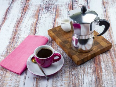 Kahve için masayı hazırla. Gayzer kahve makinesi ve çay tabağı.