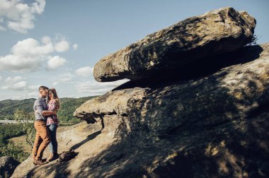 Genç hippi çift ayakta dağ kenarında 