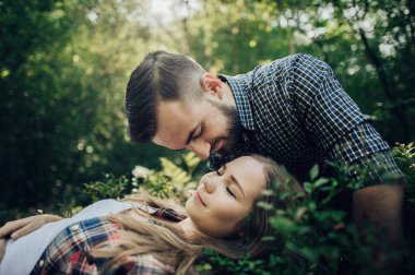 Genç kadın yalan yeşil yaprakları ve adam alin öpüşme 