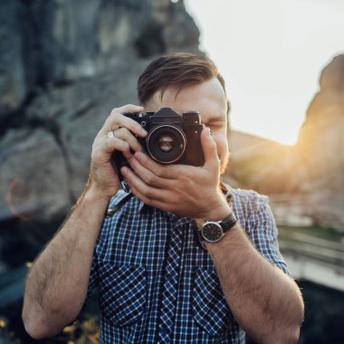 Dijital kamera önünde yüz tutan genç adam portresi 