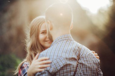 Mutlu genç çift yeşil park günbatımında sarılma 