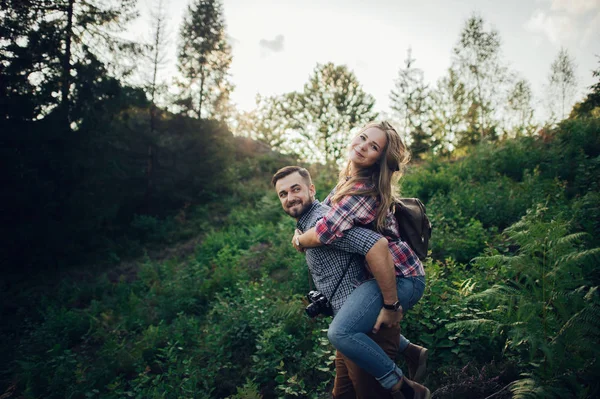 Junger Fröhlicher Mann Hält Freundin Huckepack Grünen Park Bei Sonnenuntergang — Stockfoto