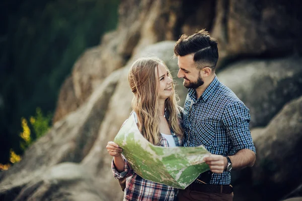 山の中の地図と若い素敵なカップルを探して正しい道 — ストック写真