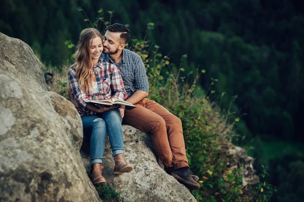Kayanın Üzerinde Oturan Kitap Okuma Genç Çift — Stok fotoğraf