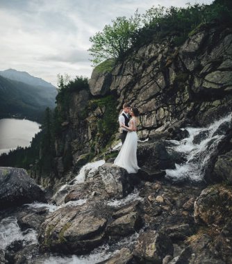 İhale çift ayakta Nehri akış ile kayalık dağ yamacında 