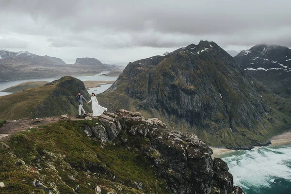 Szczęśliwy Ślub Para Podróżujący Chodzenie Wzgórzu Kvalvika Plaży Norwegia — Zdjęcie stockowe