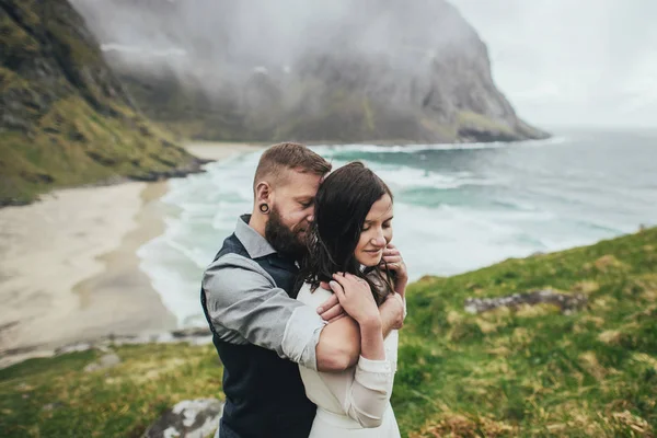 愉快的婚礼夫妇旅客拥抱在山上在 Kvalvika — 图库照片