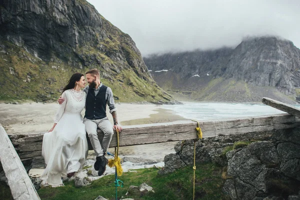 Casal Feliz Viajantes Sentados Juntos Abraçando Feixe Madeira Praia Kvalvika — Fotografia de Stock