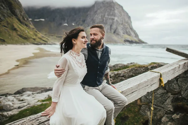 Glückliches Hochzeitspaar Das Zusammen Auf Einem Holzbalken Strand Von Kvalvika — Stockfoto