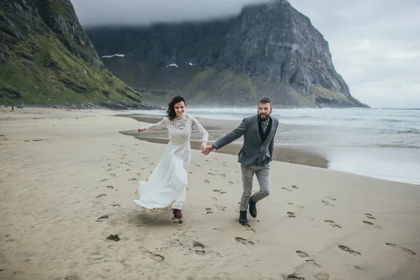 Boldog Esküvői Pár Utazó Kezét Futó Homokos Strandon Kvalvika Norvégia — Stock Fotó