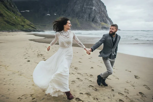 Casal Casamento Feliz Viajantes Mãos Dadas Correndo Praia Kvalvika Arenosa — Fotografia de Stock