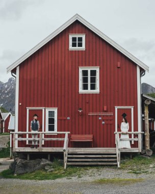 Kırmızı ahşap evin arka planda, Lofoten, Norveç ile genç yeni nikahlı çift portresi