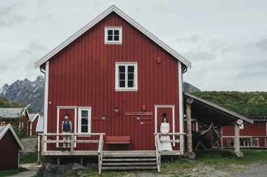 Kırmızı ahşap evin arka planda, Lofoten, Norveç ile genç yeni nikahlı çift portresi