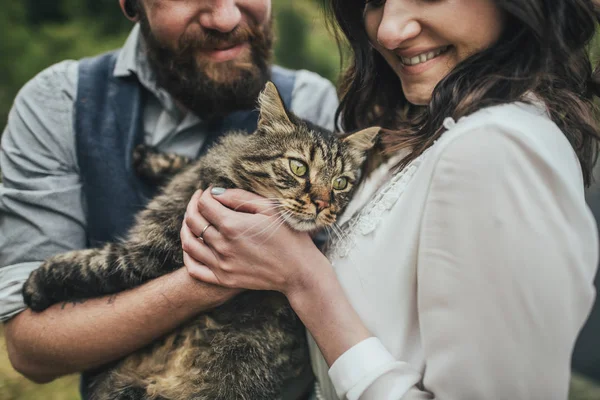 Happy couple holding and stroking cat, Norway