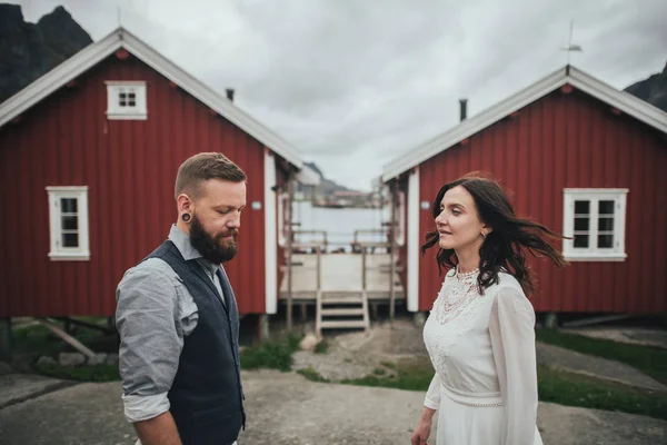 ロフォーテン諸島 ノルウェーの背景に赤の木造住宅と若い新しく結婚カップルの肖像画 — ストック写真