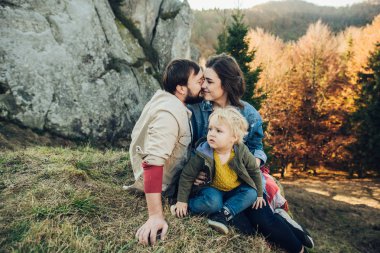 Mutlu aile: anne baba ve çocuk dağlarda. 