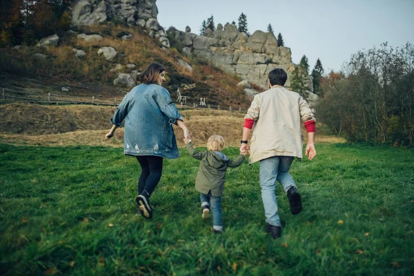 Família jovem com filho pequeno passar o tempo juntos fora . — Fotografia de Stock