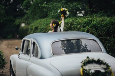 Retro araba içinde şık mutlu gelin. Duygusal an. 